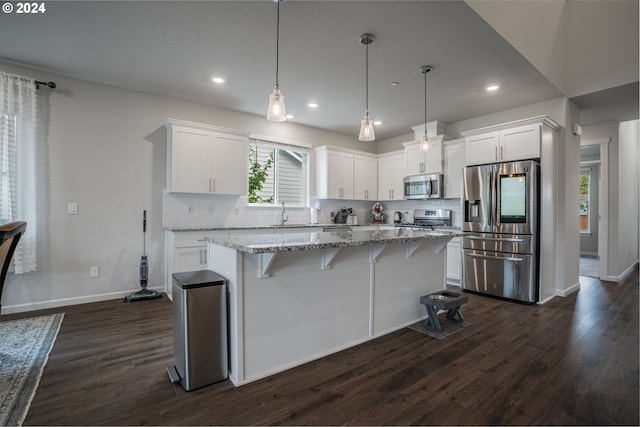 kitchen featuring white cabinetry, stainless steel appliances, a center island, hanging light fixtures, and dark wood-type flooring