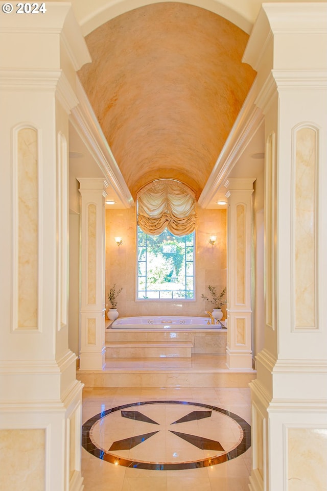 full bathroom featuring lofted ceiling, a bath, and ornate columns