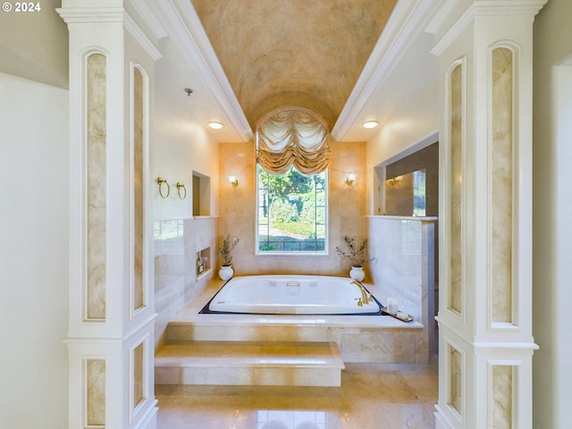 bathroom with crown molding, vaulted ceiling, a tile fireplace, ornate columns, and a bath