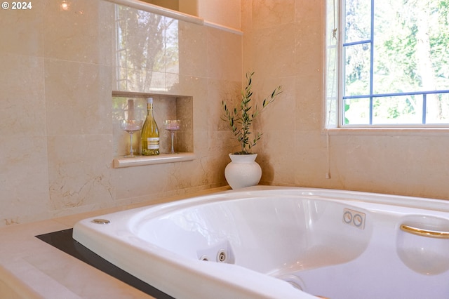 full bathroom with a tub with jets and tile walls