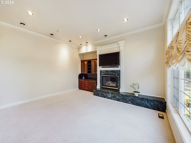 unfurnished living room with carpet flooring, a fireplace, and crown molding