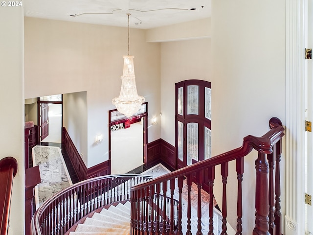 20417 SW Inglis Dr, Beaverton, OR 97007 - staircase featuring a wainscoted wall, a chandelier, and french doors