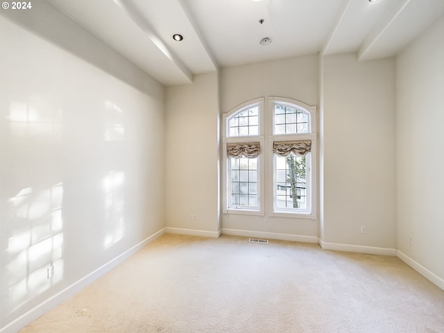 spare room with light carpet, visible vents, and baseboards