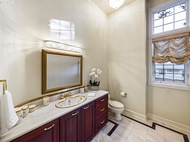 bathroom featuring toilet, baseboards, a wealth of natural light, and vanity