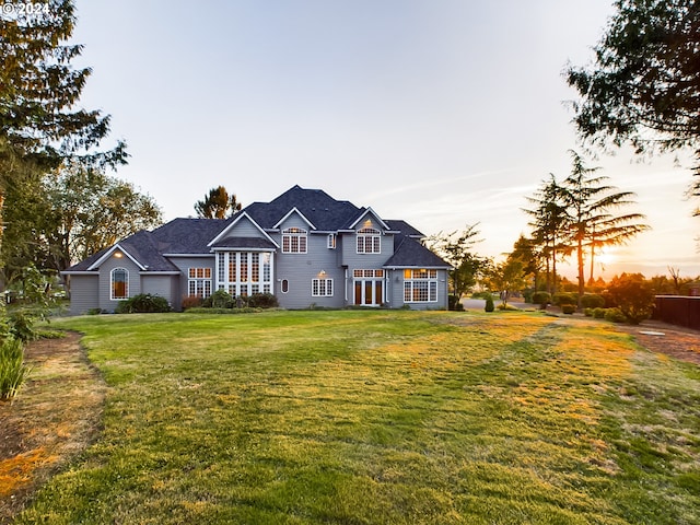 back house at dusk with a lawn