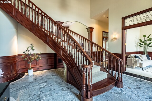 20417 SW Inglis Dr, Beaverton, OR 97007 - stairs with marble tiled floors, a towering ceiling, a wainscoted wall, recessed lighting, and a decorative wall