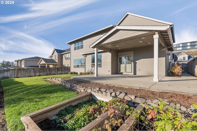 rear view of property featuring a yard and a patio area