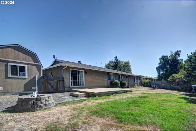 486 Ridge Dr, Gearhart, OR 97138 - rear view of property featuring fence, a deck, an outdoor fire pit, and a yard