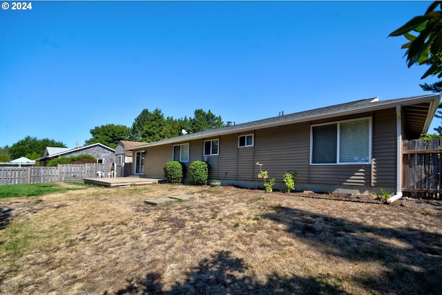 rear view of property featuring a lawn