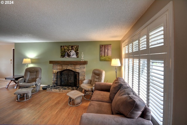 living room with a textured ceiling, a fireplace, and hardwood / wood-style flooring