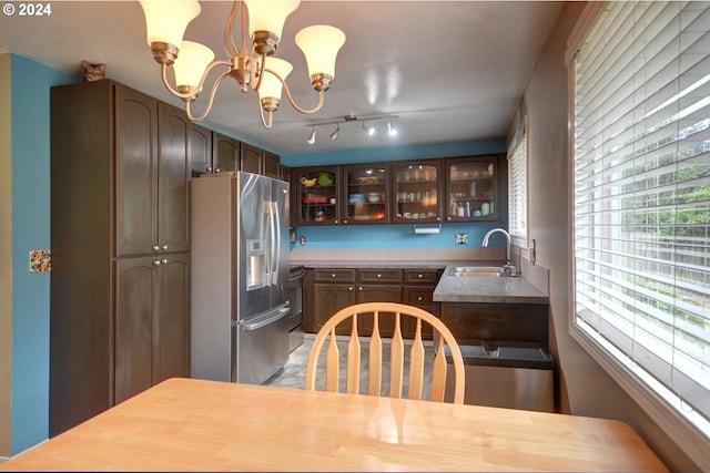 486 Ridge Dr, Gearhart, OR 97138 - kitchen featuring light countertops, stainless steel fridge, glass insert cabinets, a sink, and a notable chandelier