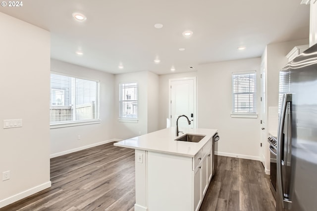 kitchen with a healthy amount of sunlight, sink, stainless steel appliances, and a center island with sink