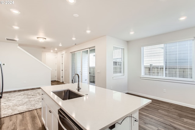 kitchen featuring dishwasher, a kitchen island with sink, dark wood-type flooring, sink, and white cabinetry