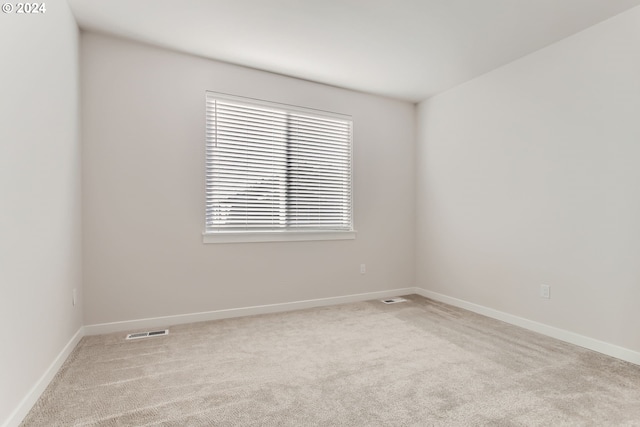 unfurnished room with light colored carpet and a wealth of natural light