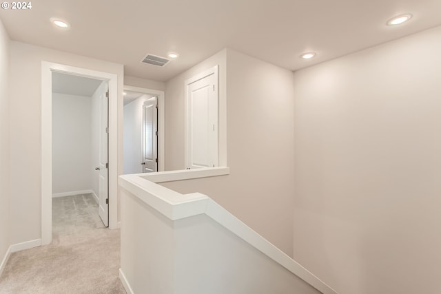 hallway featuring light colored carpet