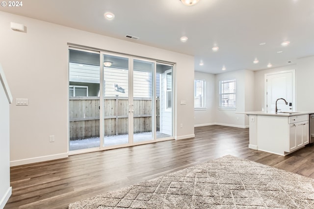 unfurnished living room with dark hardwood / wood-style flooring and sink