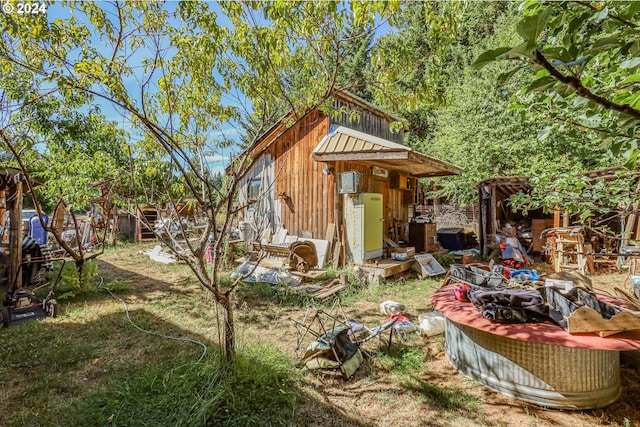 rear view of property with a storage unit