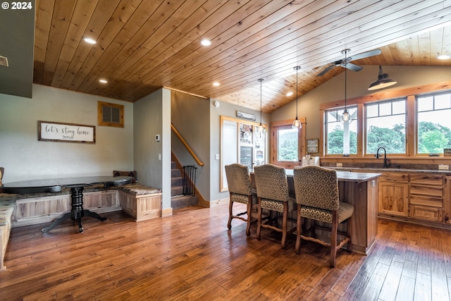 kitchen featuring visible vents, vaulted ceiling, a center island, dark wood-style floors, and decorative light fixtures