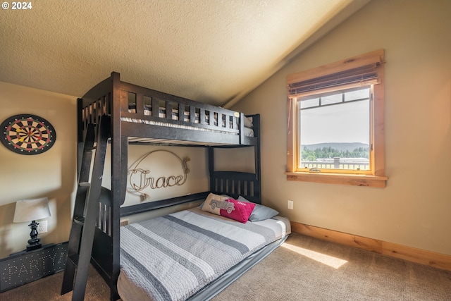 bedroom featuring lofted ceiling, baseboards, a textured ceiling, and carpet flooring