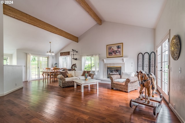 living room featuring plenty of natural light, high vaulted ceiling, dark wood-type flooring, and a tile fireplace