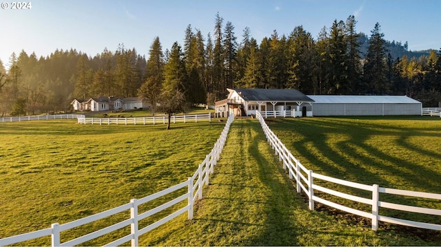 view of property's community with fence, an outbuilding, and a rural view