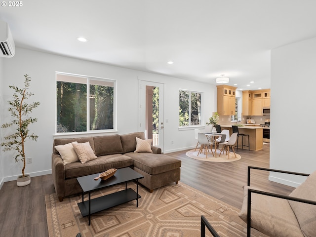 living room with light hardwood / wood-style flooring and an AC wall unit