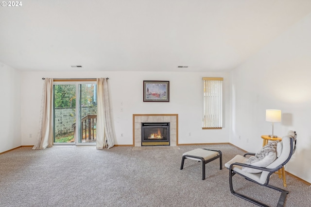 living room featuring carpet floors and a tiled fireplace