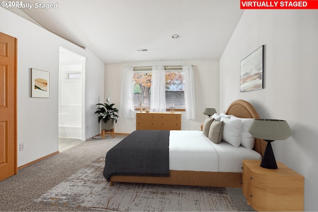 bedroom featuring carpet, ensuite bathroom, and vaulted ceiling