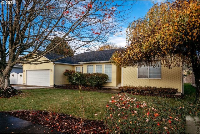 single story home with a garage and a front lawn