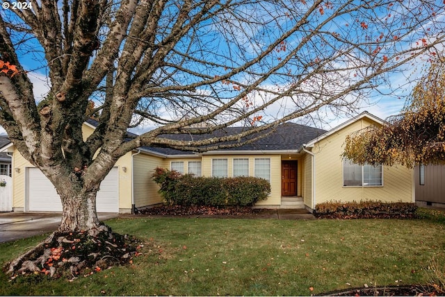 ranch-style house featuring a garage and a front yard