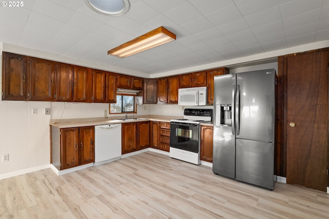 kitchen featuring sink, white appliances, and light hardwood / wood-style flooring