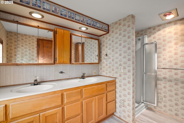 bathroom featuring an enclosed shower, vanity, and hardwood / wood-style floors