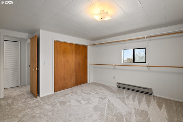 unfurnished bedroom with a baseboard radiator, light colored carpet, and a closet