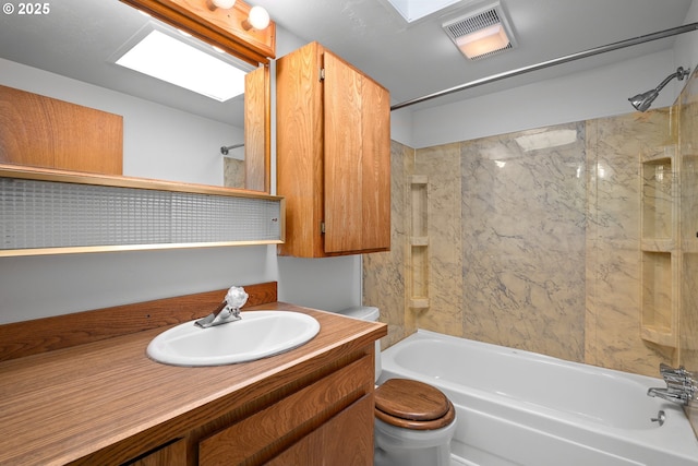 full bathroom featuring a skylight, tiled shower / bath, vanity, and toilet