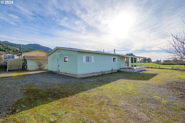 back of house featuring a yard and a mountain view