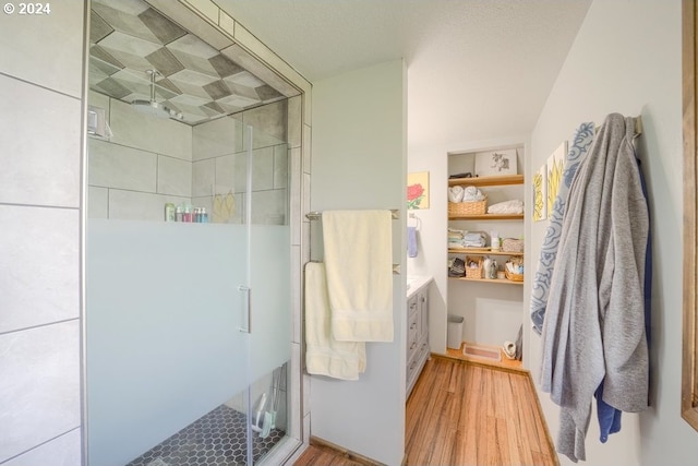 bathroom with hardwood / wood-style floors and a shower with shower door