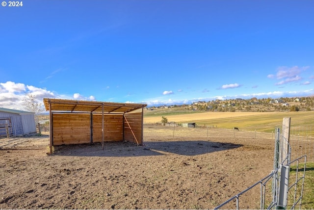 view of yard with a rural view and an outdoor structure