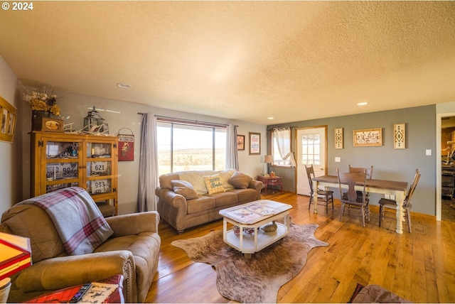 living room with light wood-type flooring and a textured ceiling