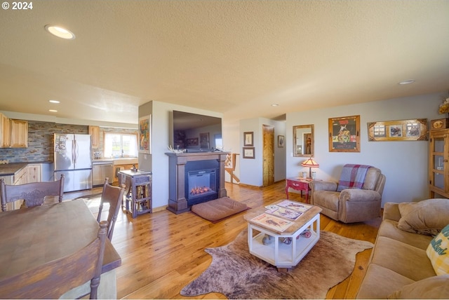 living room with a textured ceiling and light hardwood / wood-style flooring