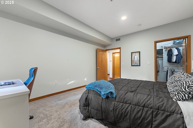 carpeted bedroom with a spacious closet and a closet