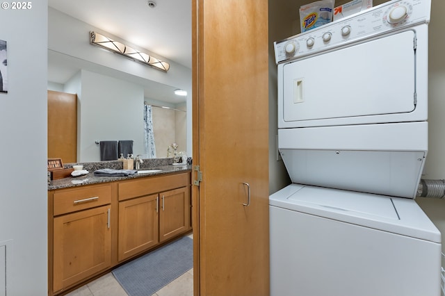 clothes washing area with stacked washing maching and dryer and sink