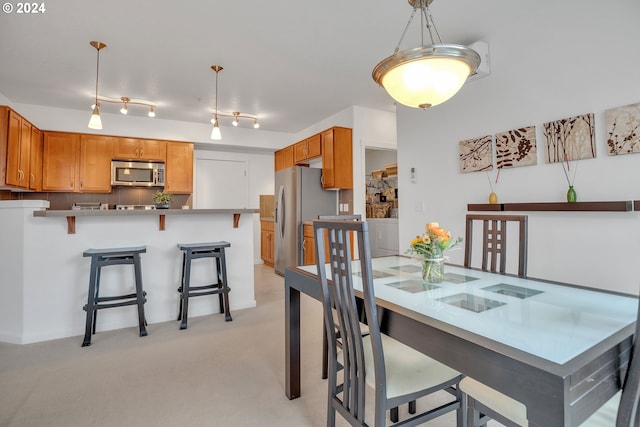 dining space featuring light carpet and independent washer and dryer