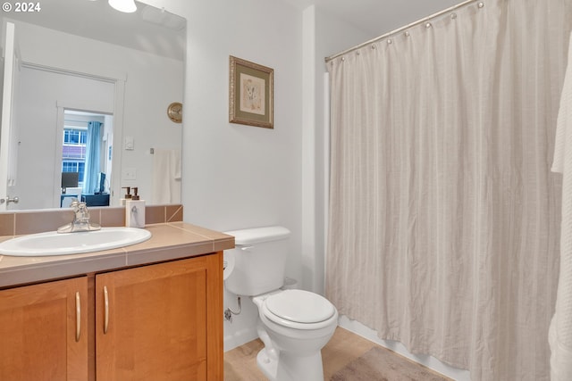 full bath with toilet, curtained shower, and vanity