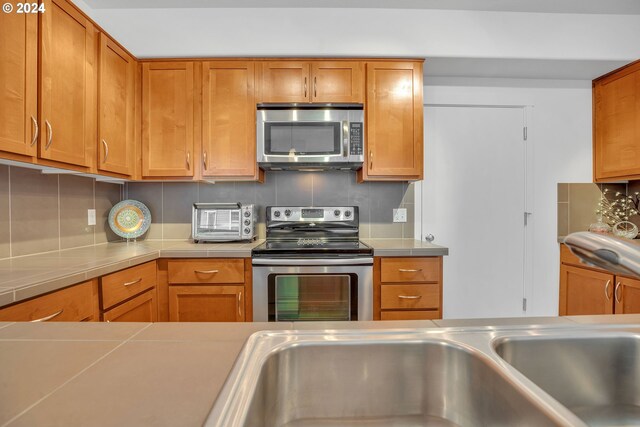 kitchen with stainless steel appliances and tasteful backsplash