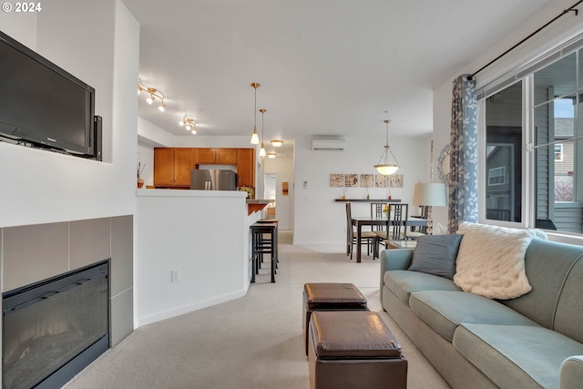 living area featuring light colored carpet, a wall mounted air conditioner, and baseboards