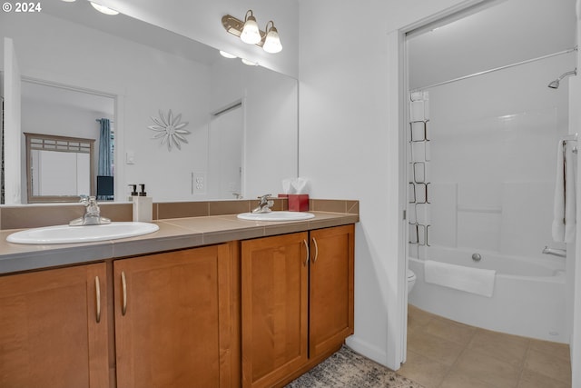 bathroom with double vanity, toilet, shower / bathtub combination, and a sink