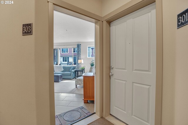 hall with light colored carpet