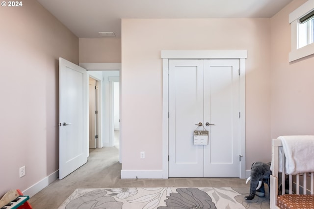 bedroom with light carpet and a closet