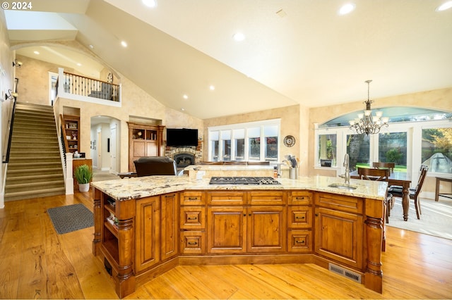 kitchen with a large island with sink, decorative light fixtures, and a healthy amount of sunlight