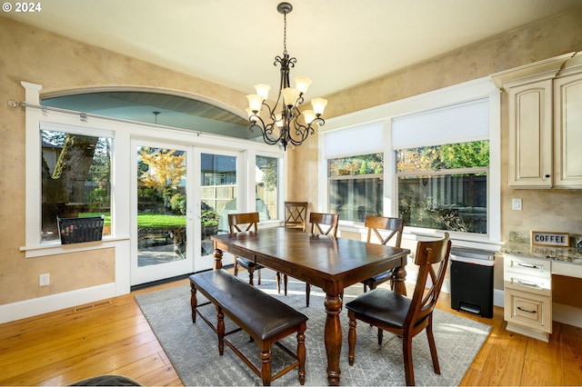 dining area featuring light hardwood / wood-style flooring, a notable chandelier, and plenty of natural light